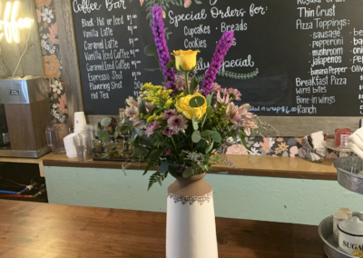 Vases with flowers and floristry tools on wooden table